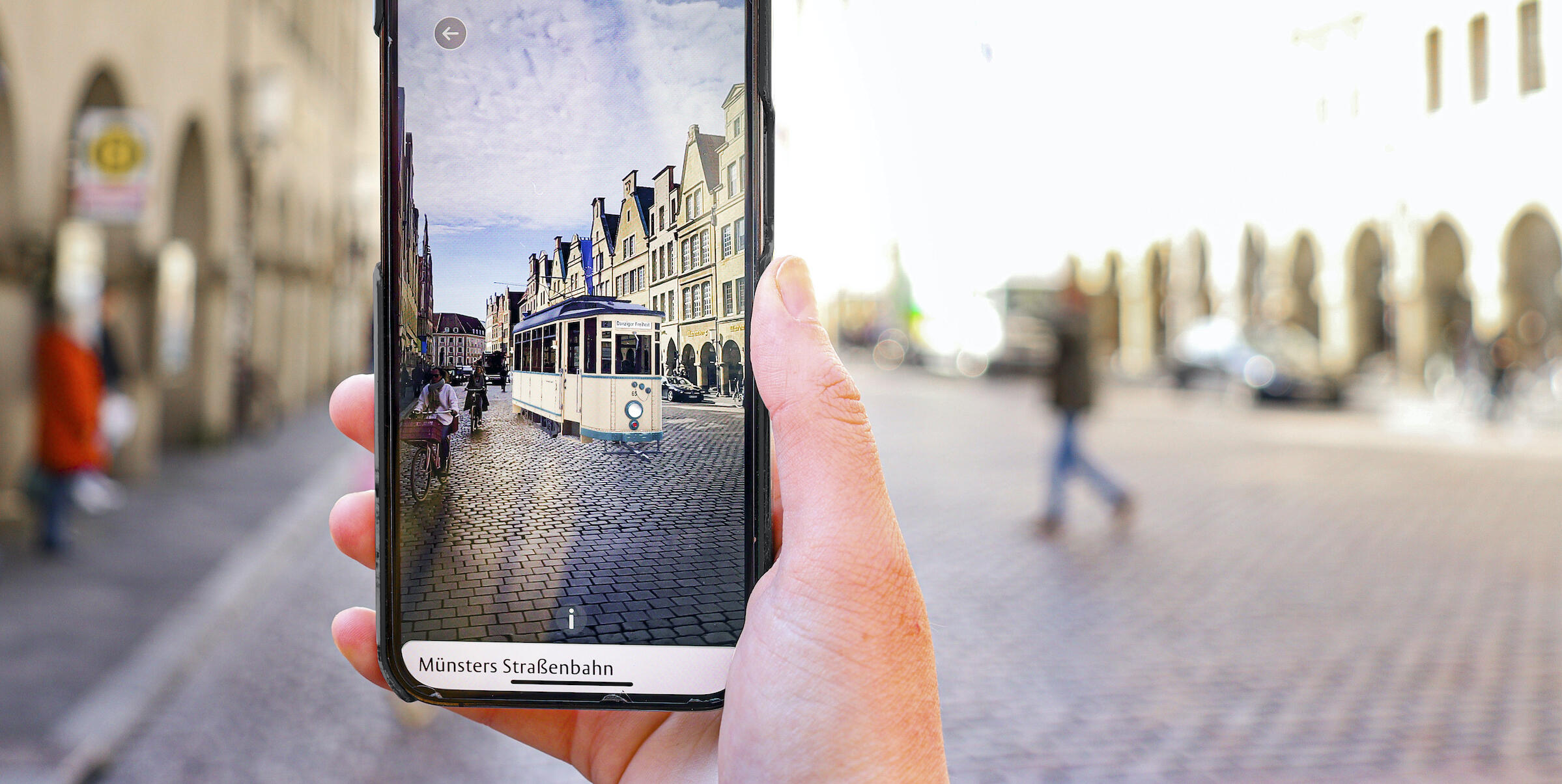 Ein Handydisplay, der den Prinzipalmarkt Münster durch die EXPLORE App zeigt
