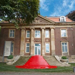 Der Eingang des Museums für Lackkunst mit rotem Teppich aus Lack