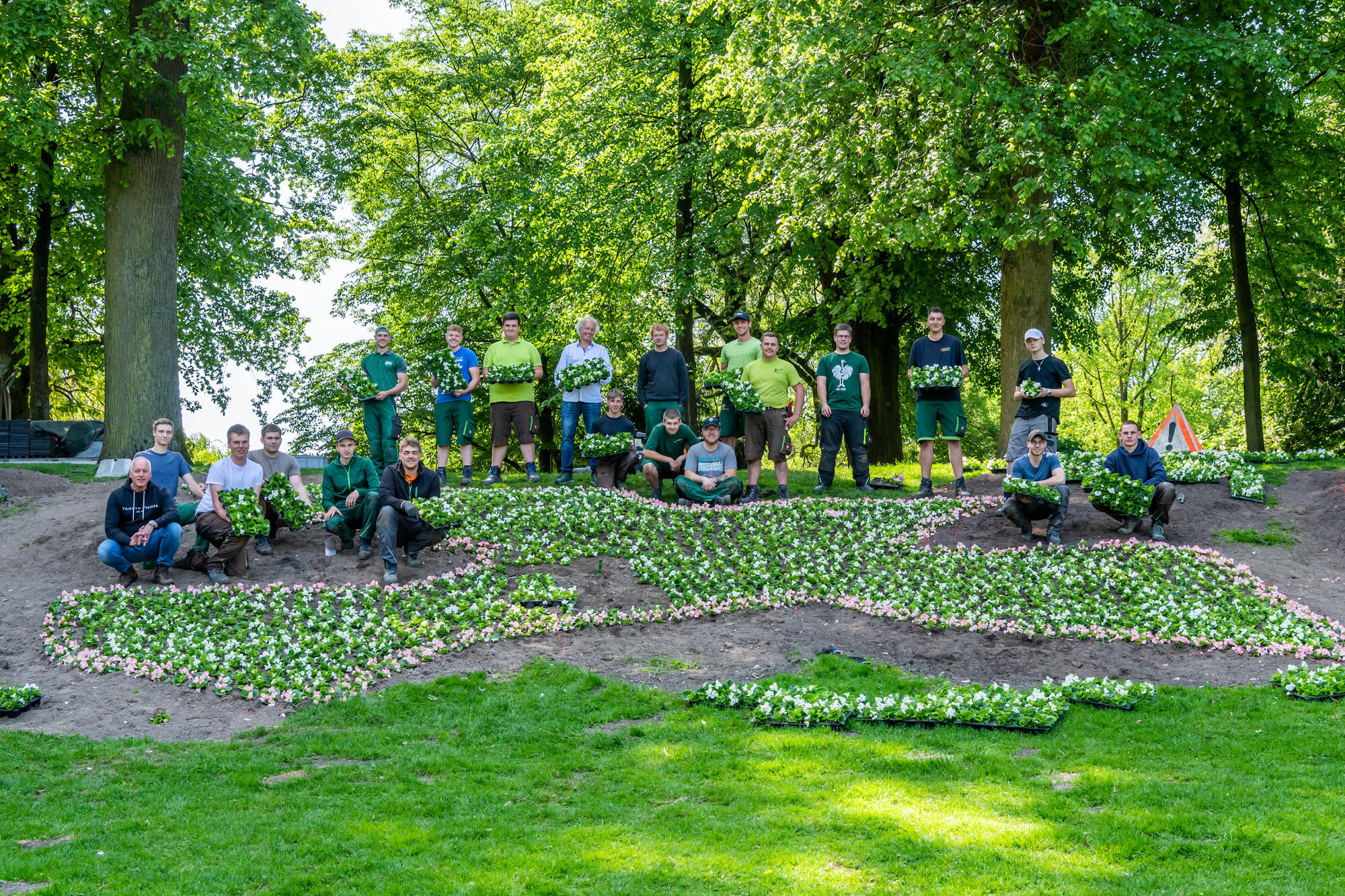 Gärtner-Azubis vor der neuen Friedensbotschaft an der Promenade