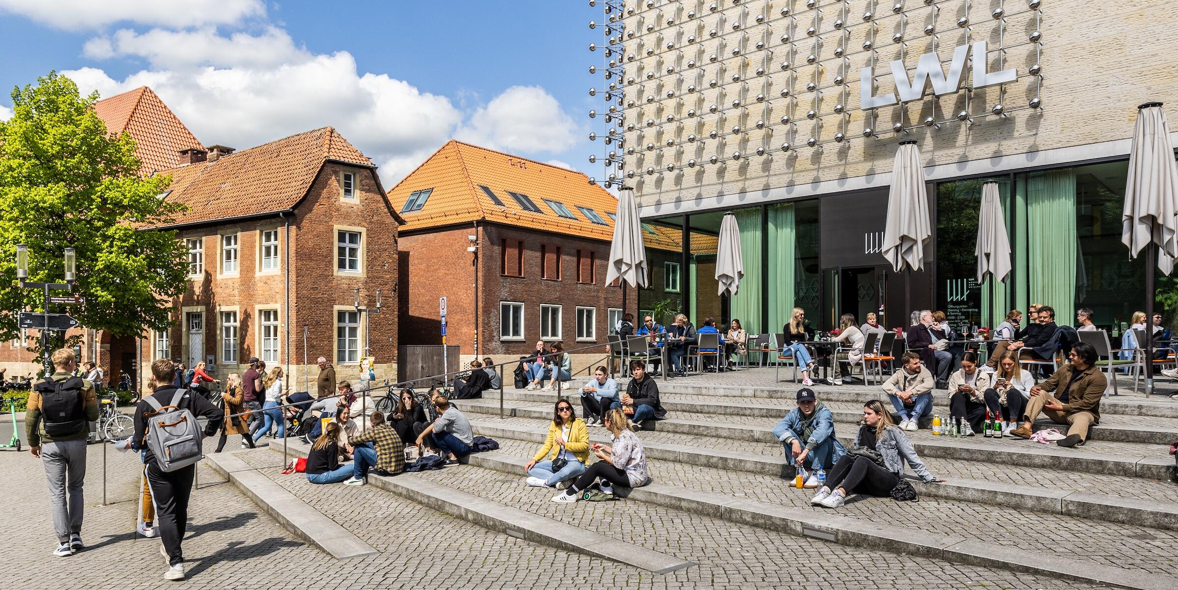 Menschen auf den Stufen vor dem LWL-Museum für Kunst und Kultur in Münster